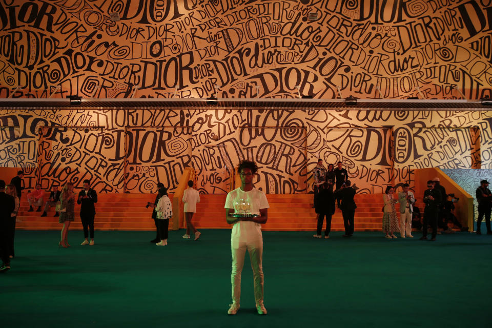 A server stands outside of the Christian Dior men's fashion show during Art Basel on Tuesday, Dec. 3, 2019, in Miami. (AP Photo/Brynn Anderson)