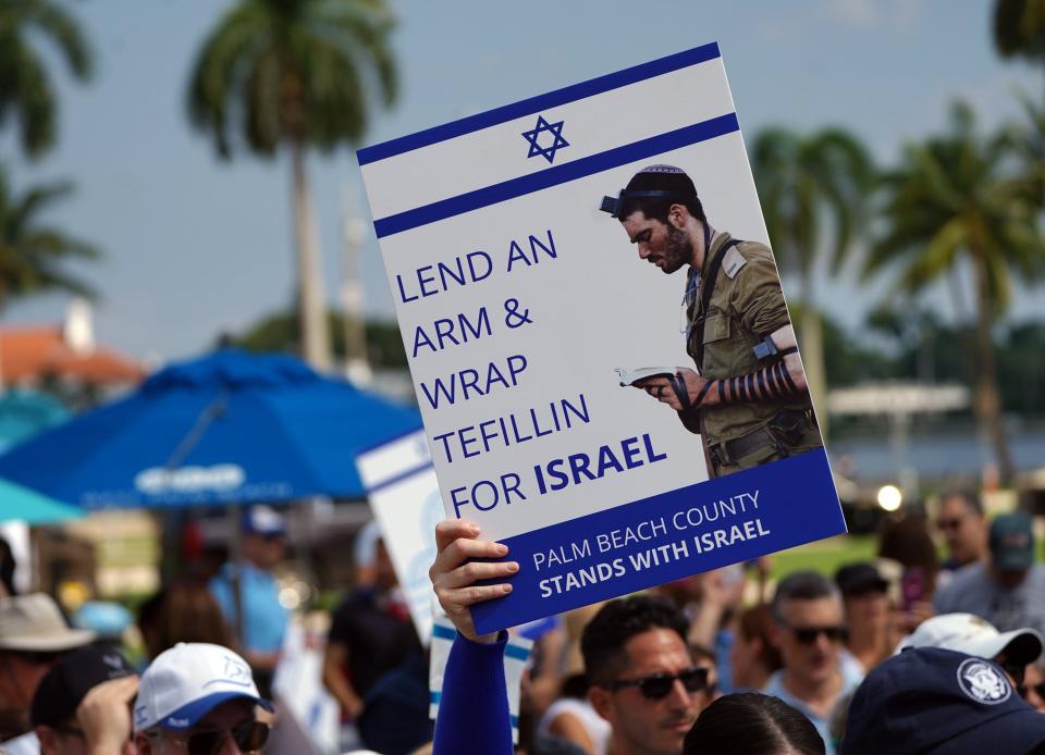 Men wrapped their arm in Tefillin, a leather wrap, during a pro-Israel rally at The Great Lawn of West Palm Beach on October 15.