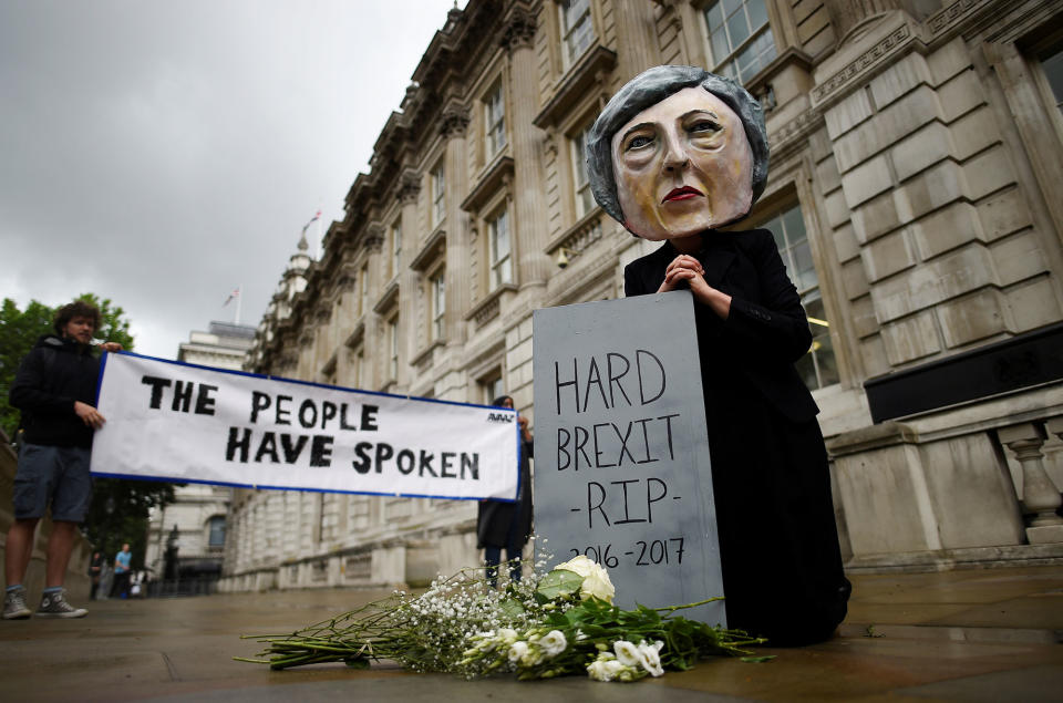 A protestor wears a Theresa May mask