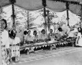 FILE - Queen Elizabeth II looks on as Queen Salote of Tonga laughs with Prince Philip, as they sit on floor in native style during a royal feast in honor of Britain's royal couple on Dec. 19, 1953, who made a two-day stop on the Island during tour of the Commonwealth. As well as celebrating Queen Elizabeth II’s Platinum Jubilee, Tu’ivakano will also remember her great- grandmother Queen Salote Tupou III, who endeared herself to Britons as she rode through the streets of London in an open carriage during Elizabeth’s coronation parade in 1953. (AP Photo, File)