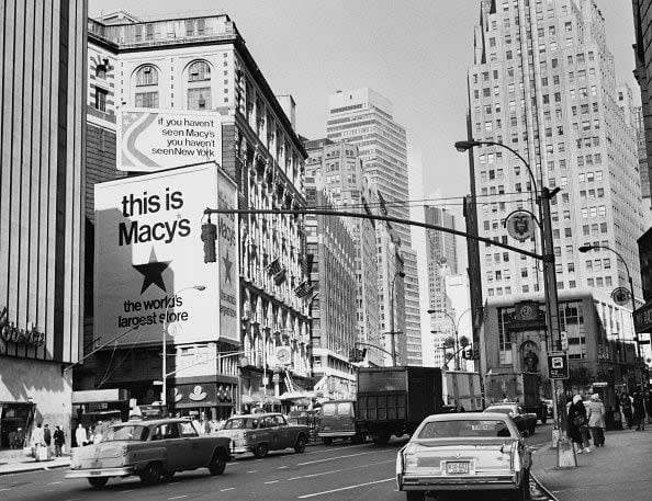 1977 Traffic passes billboards reading 'If you haven't seen Macy's, you haven't seen New York' and 'This is Macy's, the world's largest store' on the facade of Macy's department store on Broadway and West 34th Street, in the borough of Manhattan, New York City, New York, November 1977. (Photo by Peter Keegan/Keystone/Hulton Archive/Getty Images)