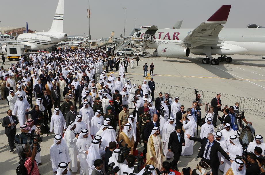 UAE Vice President, Prime Minister and Ruler of Dubai, Sheikh Mohammed bin Rashid Al Maktoum, lower center right, followed by Emirati officials and international delegations arrive for the opening day of 12th edition of the Dubai Airshow in Dubai, United Arab Emirates, Sunday Nov. 17, 2013. (AP Photo/Kamran Jebreili)