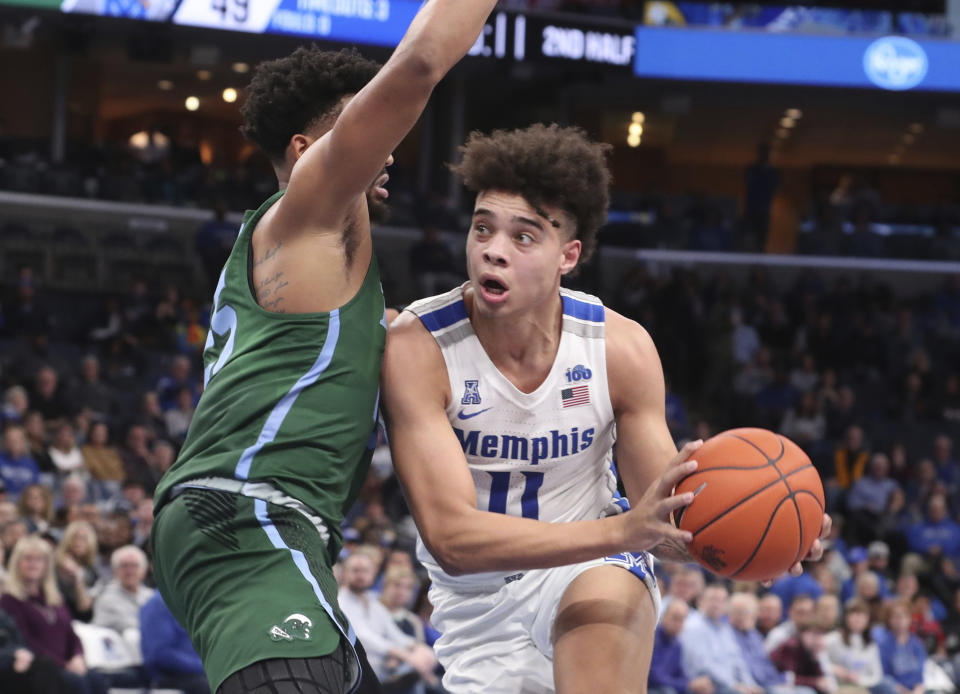 Memphis guard Lester Quinones (11) moves around Tulane guard Christion Thompson (25) in the second half of an NCAA college basketball game Monday, Dec. 30, 2019, in Memphis, Tenn. (AP Photo/Karen Pulfer Focht)