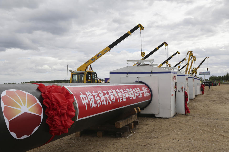 FILE - Workers gather during a ceremony to start construction of the China-Russia East Route natural gas pipeline, also known as the Power of Siberia trunk pipeline, in Heihe in northeastern China's Heilongjiang Province on June 29, 2015. Chinese leader Xi Jinping is keeping the West guessing about whether Beijing will cooperate with tougher sanctions on Russia as he meets President Vladimir Putin a year after declaring they had a “no limits” friendship ahead of the Kremlin’s invasion of Ukraine. (Chinatopix via AP, File)