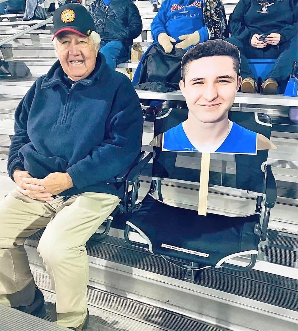 Gerry Burrell sits along the cardboard cutout of his grandson Jack Hogan during Winnacunnet's Senior Night game against Londonderry on October 21.