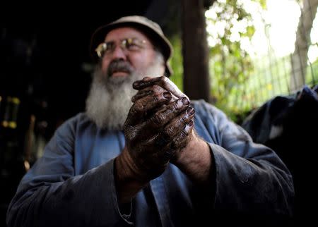 Gary Pallister cleans grime off his hands after a day's work on the Puffing Billy Railway at Belgrave station near Melbourne, October 17, 2014. REUTERS/Jason Reed