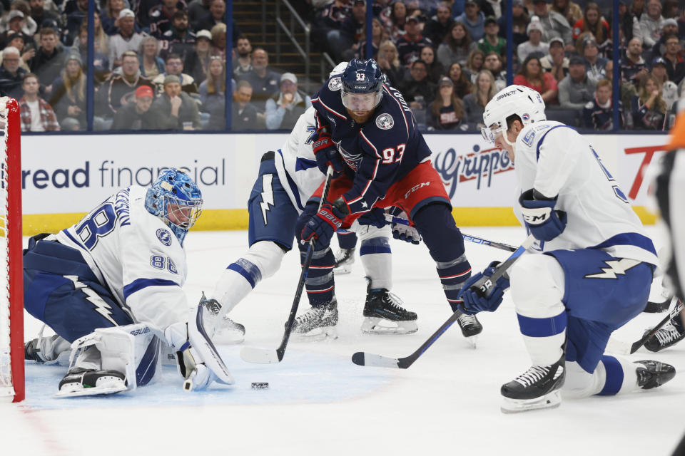 Tampa Bay Lightning's Andrei Vasilevskiy, left, makes a save as teammate Cal Foote, right, and Columbus Blue Jackets' Jakub Voracek look for the rebound during the second period of an NHL hockey game Friday, Oct. 14, 2022, in Columbus, Ohio. (AP Photo/Jay LaPrete)