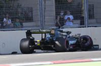 Spectators look at the car of Aston Martin driver Lance Stroll of Canada after a crash during the qualifying session at the Baku Formula One city circuit in Baku, Azerbaijan, Saturday, June 5, 2021. The Azerbaijan Formula One Grand Prix will take place on Sunday. (AP Photo/Darko Vojinovic)