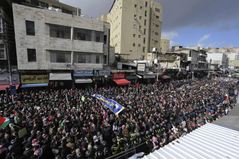 Protesters carry Jordanian and Palestinian flags and slogans during a protest against the Middle East peace plan proposed by U.S. President Donald Trump, in the center of Amman, Jordan, Friday, Jan. 31, 2020. (AP Photo/Raad Adayleh)