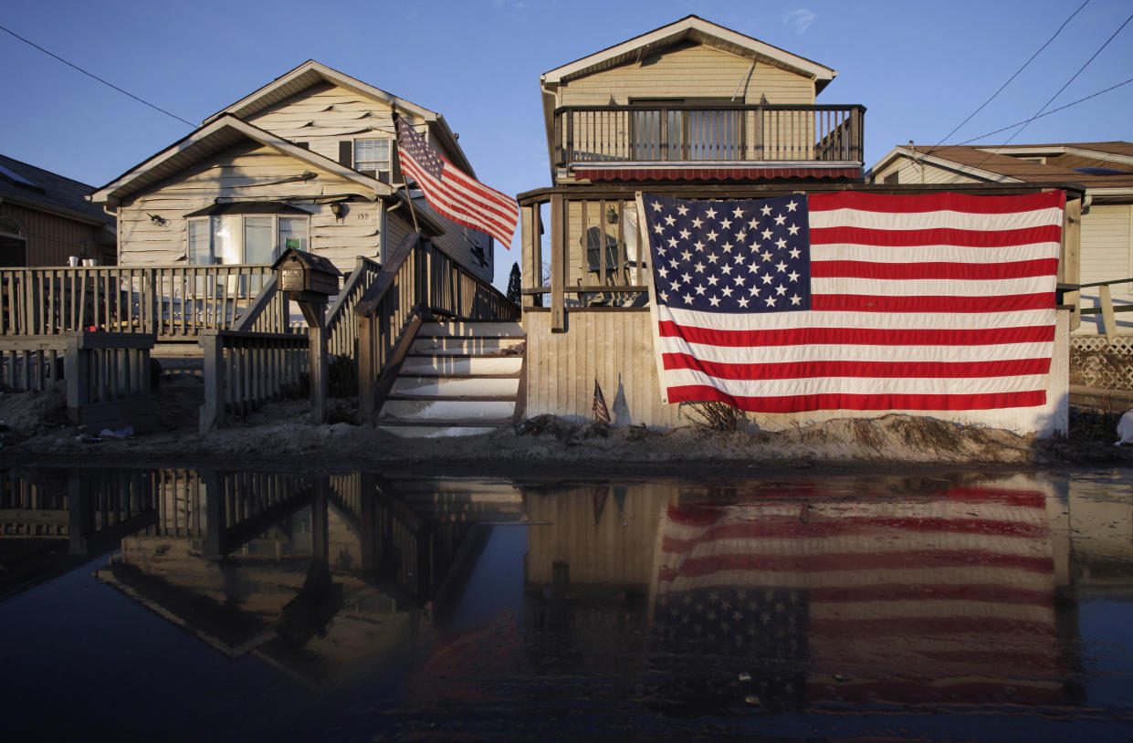 U.S. flags are displayed on flood-damaged homes in the Breezy Point section of Queens, N.Y., Nov. 28, 2012. (Photo: Mark Lennihan/AP)