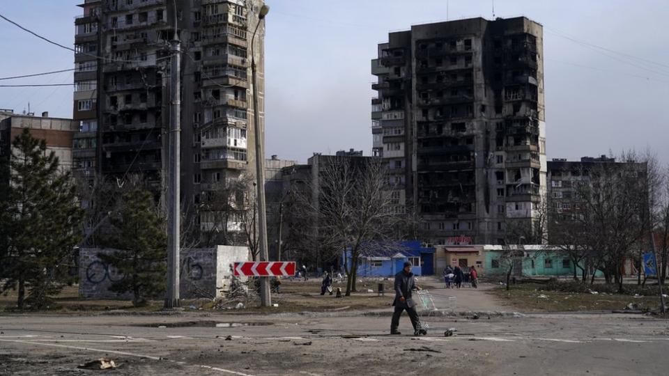 烏克蘭馬里烏波爾一位男子走過被俄軍炸成廢墟的住宅樓（20/3/2022）