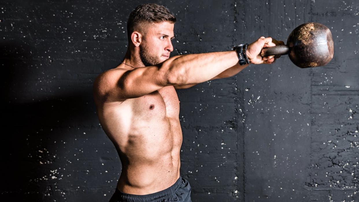  Man doing kettllebell swing exercise . 