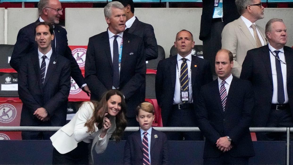 Prinz William (r) und seine Frau Kate mit dem kleinen Prinz George  auf der Tribüne des Wembley-Stadions.