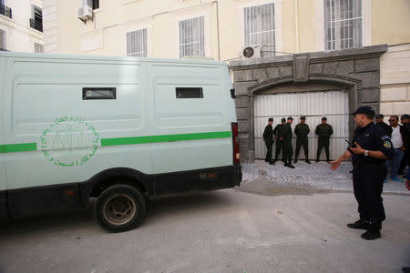 Police officers wait near a prisoner transport vehicle by the gate of a court, after businessmen suspected of corruption were driven into the building in Algiers, Algeria April 23, 2019. REUTERS/Ramzi Boudina