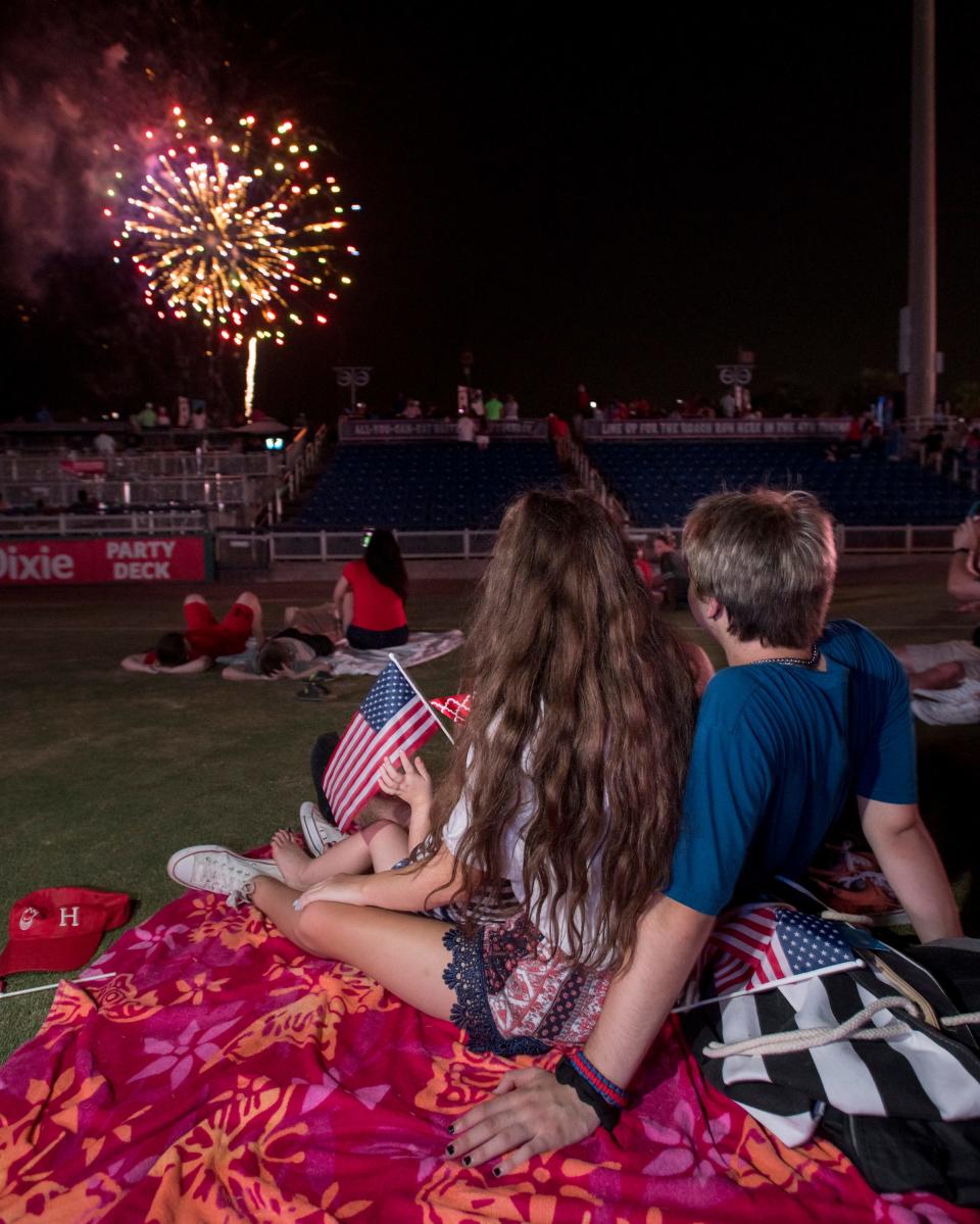 Attendees watch a previous Symphony, Sparks & Stars fireworks show at Blue Wahoos Stadium in downtown Pensacola.