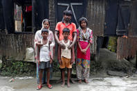 Riyazul Haq (C), his son Sahil Shaikh (C-foreground) and his daughter Rimpi Khatun (R) whose names are excluded from the draft list of the National Register of Citizens (NRC), pose for a picture with other family members inside their home in Dhubri district, in the northeastern state of Assam, India August 3, 2018. REUTERS/Adnan Abidi