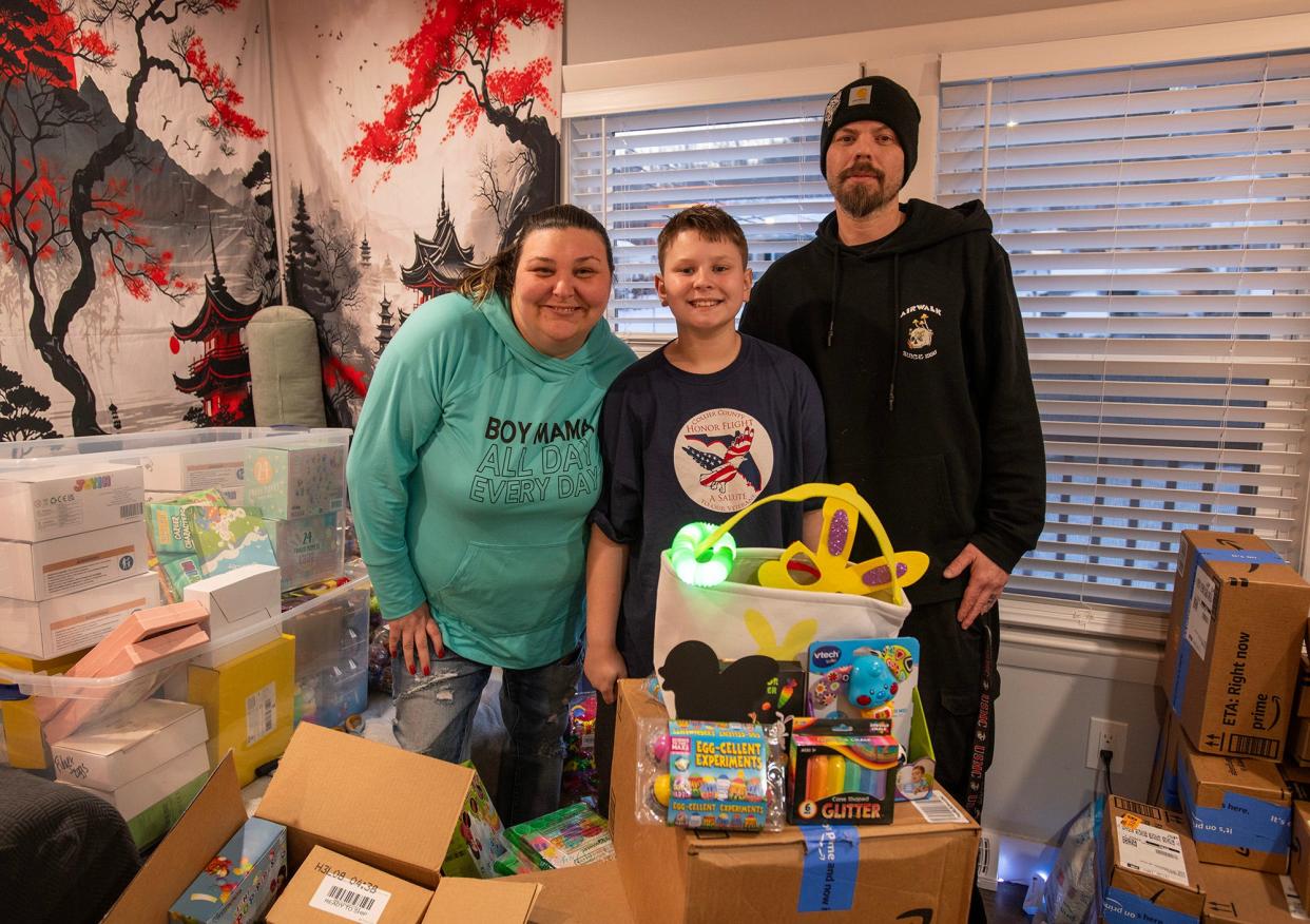 Joshua Sowden, 12, stands with his parents, Nickolas and Crystal Sowden, among the boxes of items that will go into Easter baskets.
