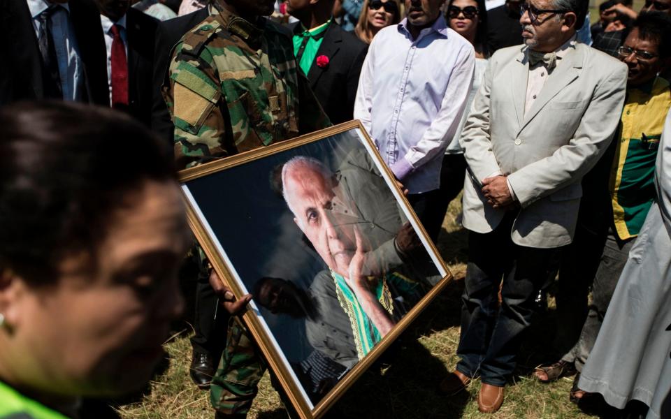 A member of former South African military wing Mkhonto We Sizwe carries the portrait of Anti-apartheid stalwart Ahmed Kathrada during the funeral - Credit: AFP