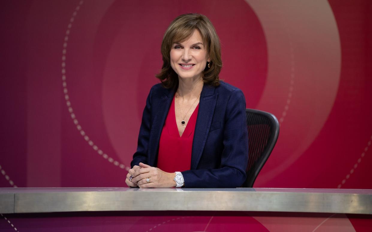 Fiona Bruce poses behind a desk on the Question Time set