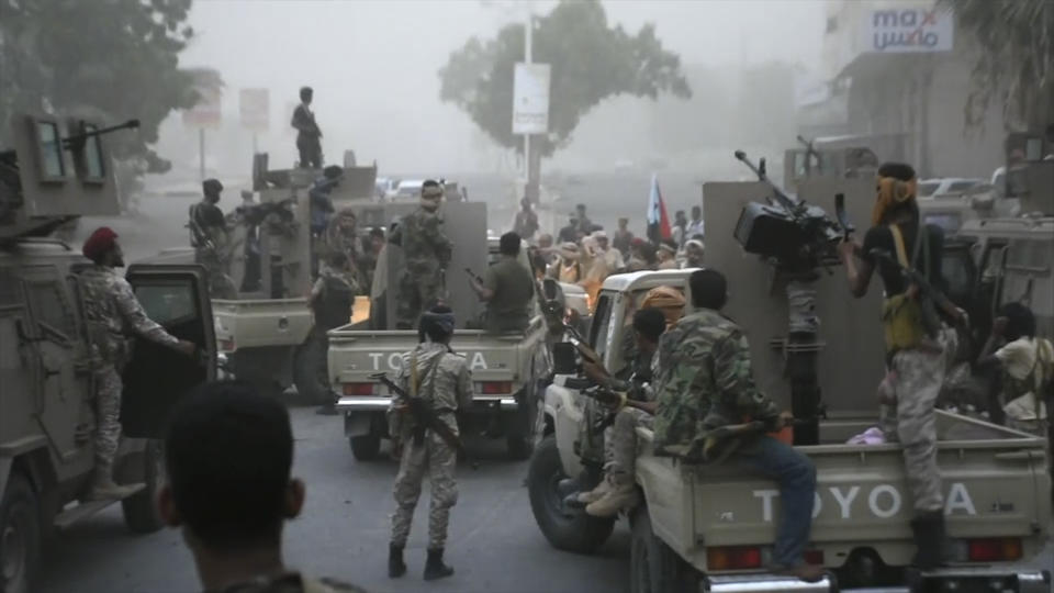 In this Friday Aug. 9, 2019 frame grab from video, Southern Transitional Council separatist fighters line up to storm the presidential palace in the southern port city of Aden, Yemen. The separatists backed by the United Arab Emirates began withdrawing Sunday from positions they seized from the internationally-recognized government in Aden. Both the southern separatists and the government forces are ostensibly allies in the Saudi-led military coalition that’s been battling the Houthi rebels in northern Yemen since 2015, but the four days of fighting in Aden have exposed a major rift in the alliance. (AP Photo)