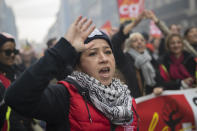 A protester raises her hand during a demonstration in Marseille, southern France, Friday, Jan. 24, 2020. French unions are holding last-ditch strikes and protests around the country Friday as the government unveils a divisive bill redesigning the national retirement system. (AP Photo/Daniel Cole)