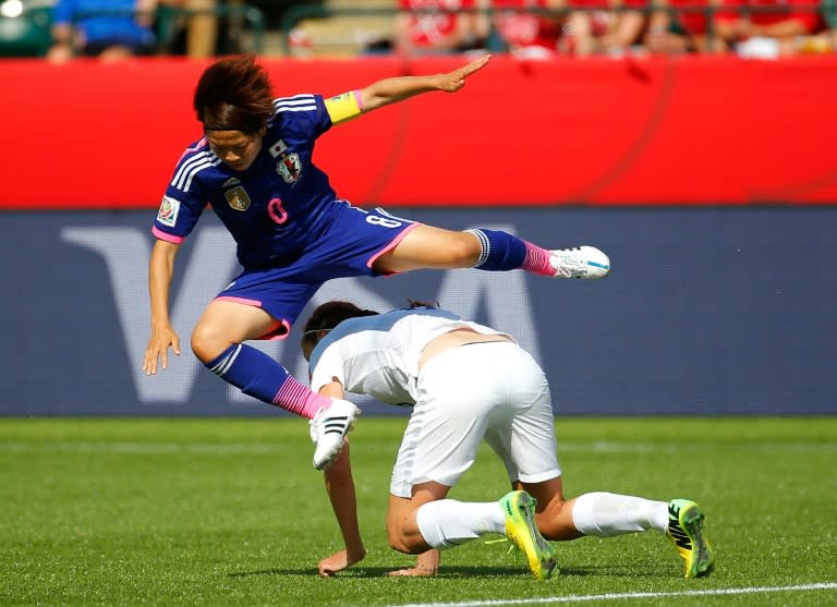 Aya Miyama of Japan leaps over England's Jill Scott in the Women's World Cup Semi Final on July 1, 2015 in Edmonton, Canada