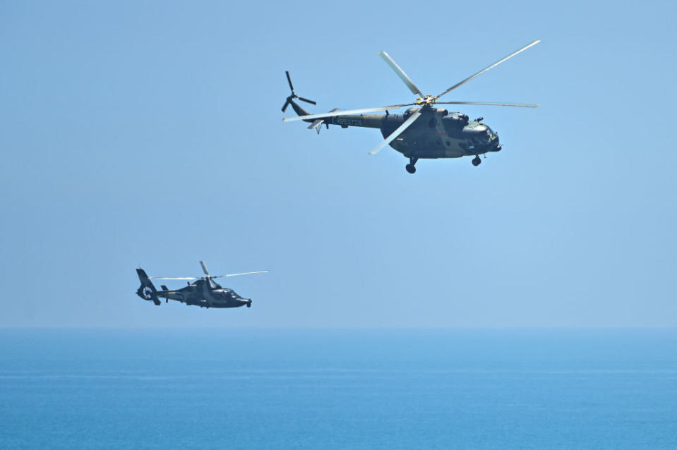 Chinese military helicopters fly past Pingtan island, one of mainland China's closest point from Taiwan, in Fujian province on August 4, 2022, ahead of massive military drills off Taiwan following US House Speaker Nancy Pelosi's visit to the self-ruled island.<span class="copyright">Hector Retamal—AFP/Getty Images</span>