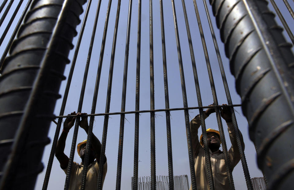 Indian laborers work at a construction site in Gauhati, India, Friday, March 16, 2012. Indian Finance Minister, Pranab Mukherjee, presented India's new budget Friday amid concerns about inflation, the country's falling growth rate and its large deficit. (AP Photo/Anupam Nath)