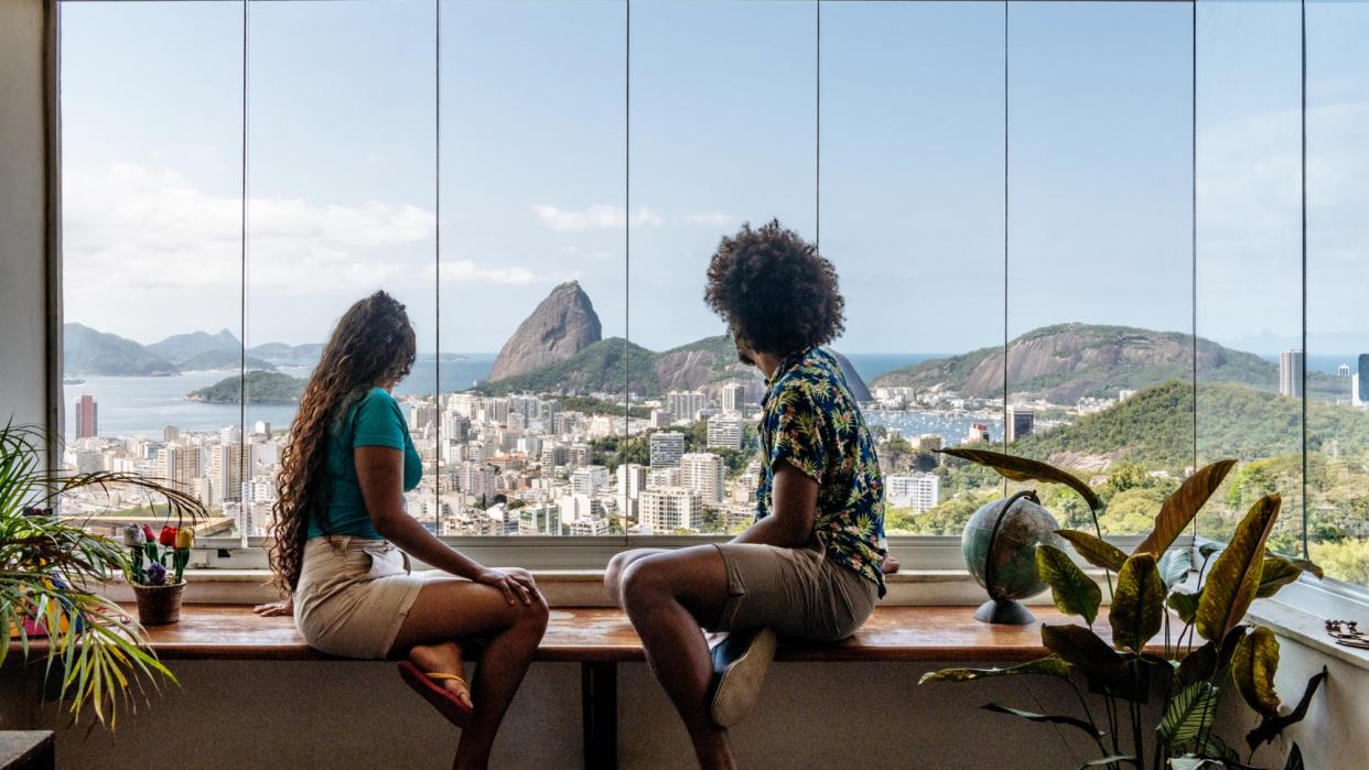  Couple on holiday in Rio de Janeiro, sitting at table, enjoying the view. 