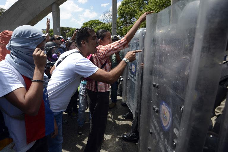 Anti-government activists confront the National Police during a protest against Venezuelan President Nicolas Maduro, in Caracas, on March 20, 2014