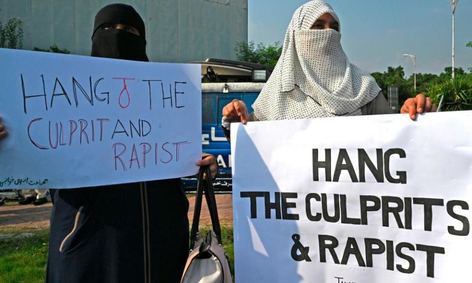 Two women with signs says 'Hang the culprit and rapist'.