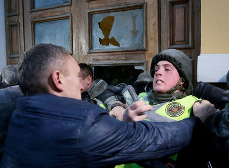 Supporters of former Georgian President and Ukrainian opposition figure Mikheil Saakashvili clash with police as they try to break into the building of the International Art Centre in Kiev, Ukraine, December 17, 2017. REUTERS/Valentyn Ogirenko