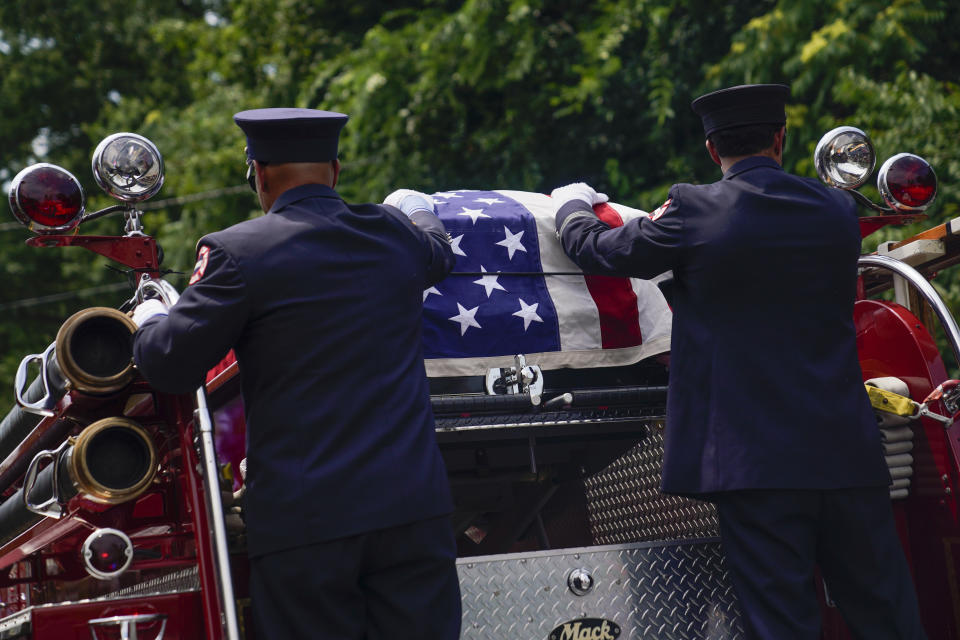 The casket of Newark firefighter Augusto "Augie" Acabou departs aboard a firetruck hearse after being carried from the Cathedral Basilica of the Sacred Heart during his funeral days after he died battling a fire aboard the Italian-flagged Grande Costa d'Avorio cargo ship at the Port of Newark, Thursday, July 13, 2023, in Newark, N.J. The fire also claimed the life of Wayne "Bear" Brooks Jr. (AP Photo/John Minchillo)