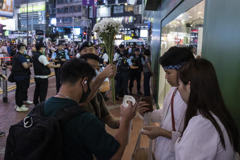 Police officers conduct a search on a member of the public in the Causeway Bay area on the eve of the 34th anniversary of China's Tiananmen Square massacre, in Hong Kong, Saturday, June 3, 2023. (AP Photo/Louise Delmotte)