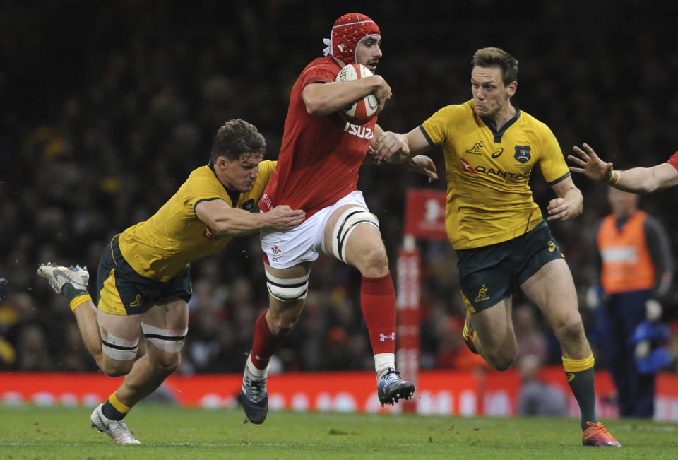 Wales Cory Hill runs between Australia's Dane Haylett-Petty, right, and Michael Hooper during the rugby union international match between Wales and Australia at the Principality Stadium in Cardiff, Wales, Saturday, Nov. 10, 2018. (AP Photo/Rui Vieira)