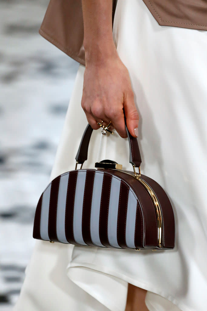 <p>A model carries a striped half-moon bag from the Adeam FW18 show. (Photo: Getty Images) </p>