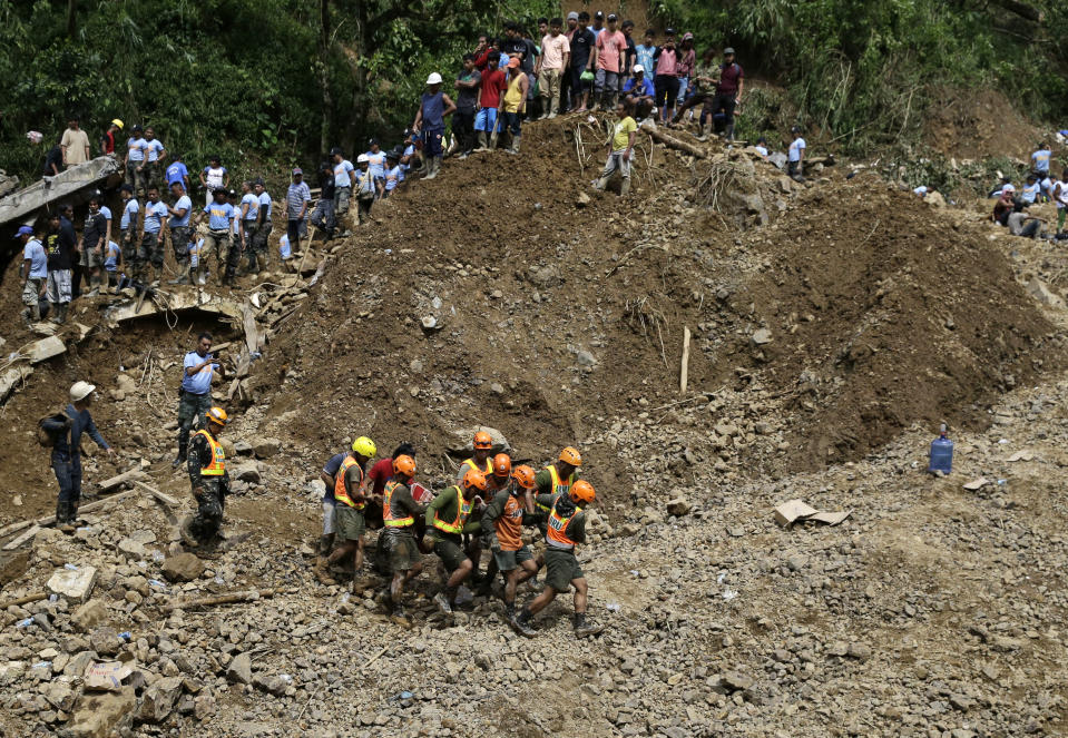 Rescuers retrieve a body they recovered at the site where victims are believed to have been buried by a landslide after Typhoon Mangkhut lashed Itogon, Benguet province, northern Philippines on Monday, Sept. 17, 2018. Itogon Mayor Victorio Palangdan said that at the height of the typhoon's onslaught Saturday afternoon, dozens of people, mostly miners and their families, rushed into an old three-story building in the village of Ucab. The building, a former mining bunkhouse that had been transformed into a chapel, was obliterated when part of a mountain slope collapsed. (AP Photo/Aaron Favila)