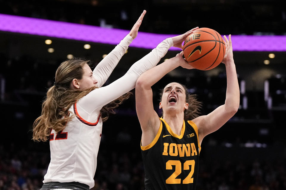 Virginia Tech guard Cayla King, left, blocks a shot by Iowa guard Caitlin Clark (22) during the first half of an NCAA women's college basketball game Thursday, Nov. 9, 2023, in Charlotte, N.C. (AP Photo/Chris Carlson)