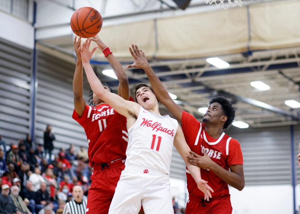 Laingsburg's Jackson Audretsch, center, and Ecorse's Deonatae Jude, left, and Tahjay Rose fight for a rebound, Tuesday, March 21, 2023, at Ypsilanti Lincoln High School.