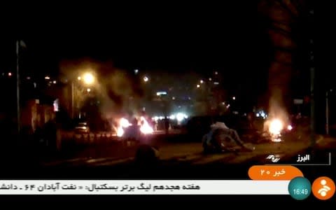  Smoke and fire spots are seen during a protest in Tuyserkan, Iran, in this still image taken from video on December 31 - Credit: REUTERS