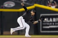 Arizona Diamondbacks third baseman Asdrubal Cabrera reaches out to field a grounder hit by Cincinnati Reds' Nick Castellanos, before throwing to first base for the out during the first inning of a baseball game Saturday, April 10, 2021, in Phoenix. (AP Photo/Ross D. Franklin)