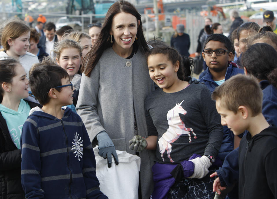 New Zealand Prime Minister Jacinda Ardern leads a group of schoolchildren on a beach cleanup Friday, Aug. 10, 2018, at Lyall Bay in Wellington, New Zealand. Ardern announced Friday that New Zealand plans to ban disposable plastic shopping bags by next July as the nation tries to live up to its clean-and-green image. (AP Photo/Nick Perry)
