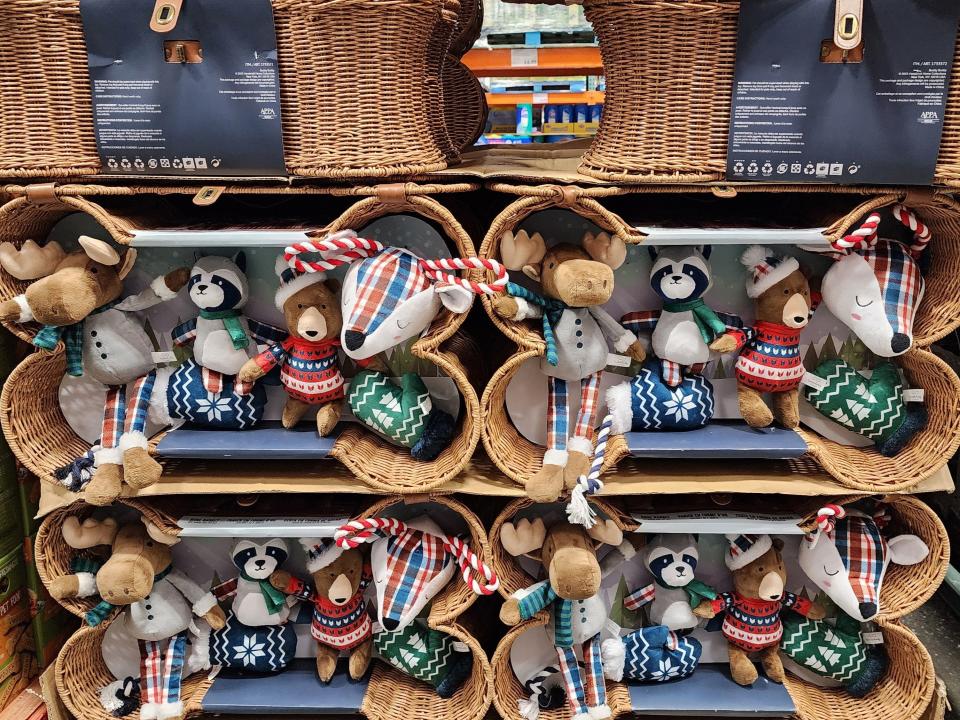 Four Buddy Buddy dog-toy baskets filled with deer, raccoon, and mitten plush toys