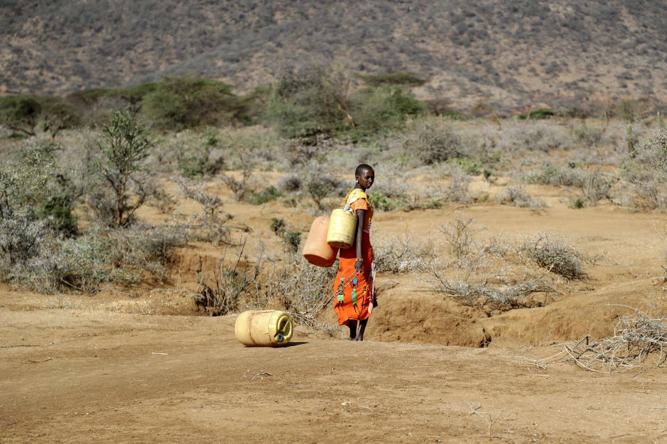 Una mujer de samburu camina para recoger agua en la escuela primaria de Loolkuniyani, en el condado de Samburu, Kenia, el domingo 16 de octubre de 2022. La agencia de Naciones Unidas para el agua estima que unos 400 millones de personas en África no tienen acceso a agua limpia. (AP Foto/Brian Inganga)