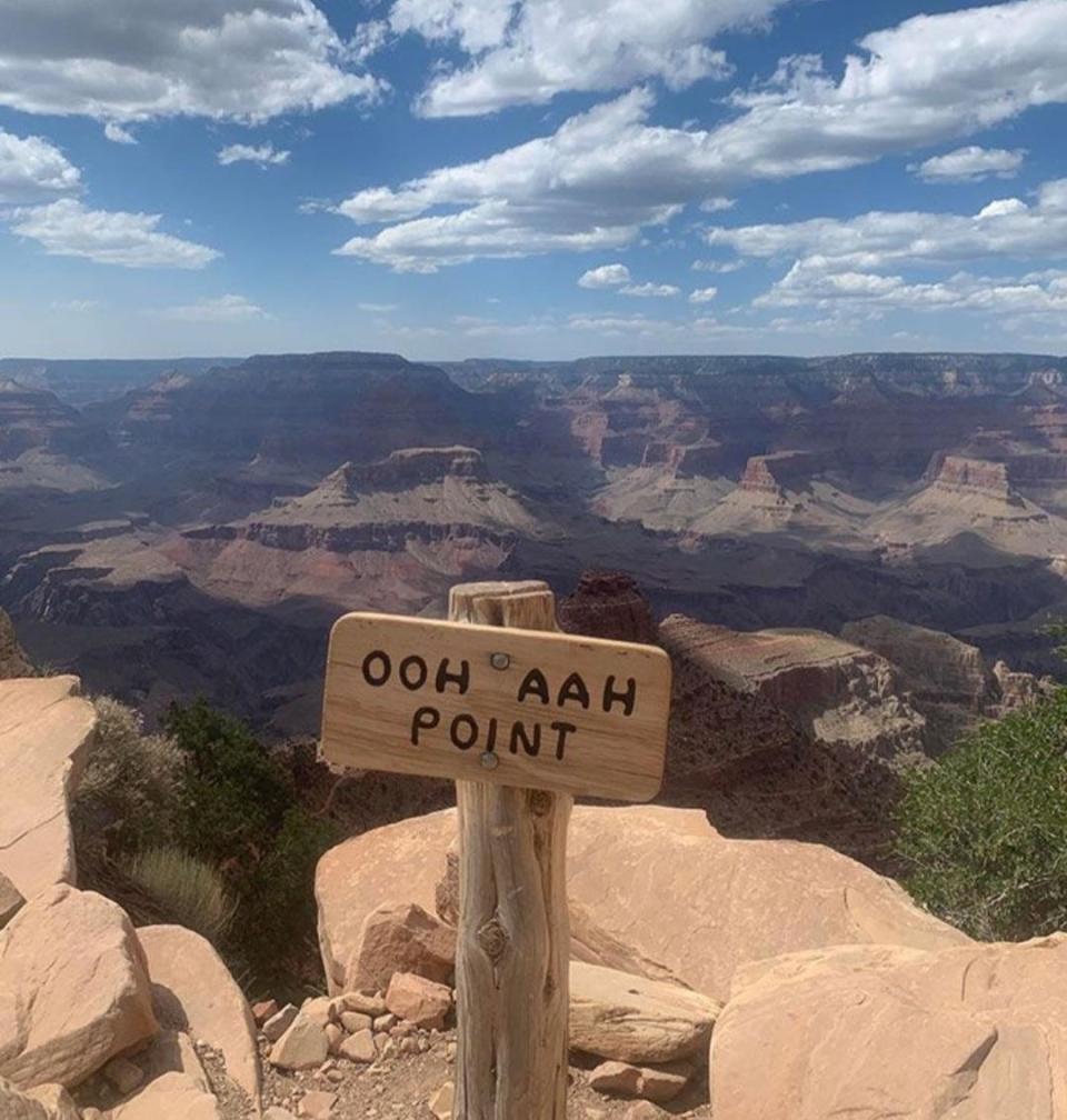 Sign in front of the Grand Canyon that says "Ooh aah point"