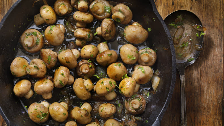 Person cooking mushrooms in a pan