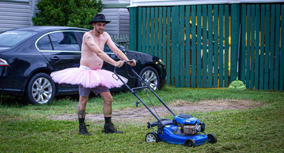 People wearing crazy outfits while they mow their lawn