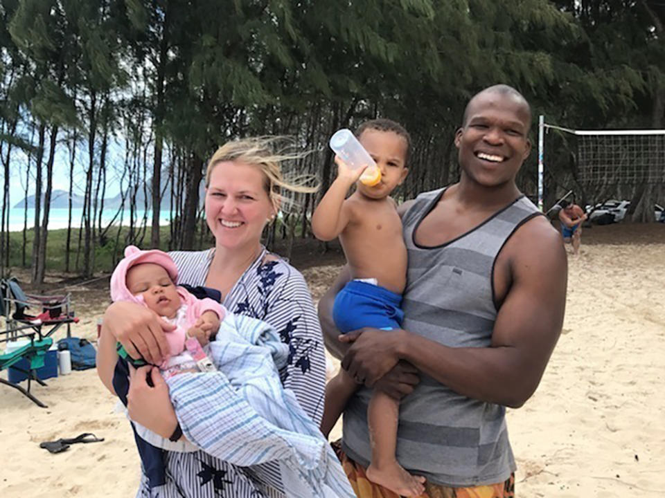 FILE - In a 2021 file photo provided by Bickerton Law Group representing the family of Lindani Myeni shows Myeni standing on a beach in Waimanalo, Hawaii with his wife and two children. Myeni was fatally shot by Honolulu police in 2021 after he physically attacked officers, who responded when an upset occupant of a home complained a stranger had entered uninvited wearing a feathered headband and made bizarre comments. Results of studies of Myeni's brain tissue, obtained by The Associated Press, show the 29-year-old South African rugby player had Stage 3 CTE, or brain trauma caused by repeated concussions. (Myeni Family Photo/Bickerton Law Group via AP, File)