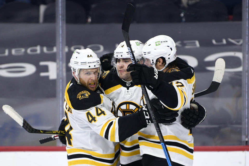 Boston Bruins' Jake DeBrusk, center, celebrates his goal with Steven Kampfer (44) and Craig Smith during the second period of an NHL hockey game against the Philadelphia Flyers, Saturday, April 10, 2021, in Philadelphia. (AP Photo/Derik Hamilton)