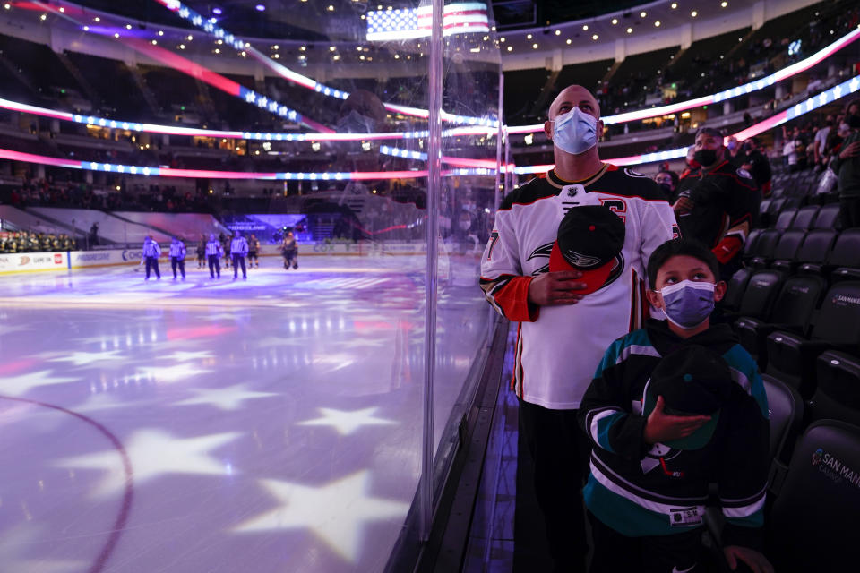 Fans listen to the national anthem before an NHL hockey game between the Anaheim Ducks and the Vegas Golden Knights, Saturday, April 24, 2021, in Anaheim, Calif. (AP Photo/Jae C. Hong)